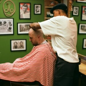a man getting his hair cut at a barber shop